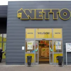 Wejście do sklepu Netto. Obok parking dla niepełnosprawnych. Aplikacja Netto pomoże Ci znaleźć najlepsze okazje.