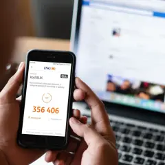 Oszustwo na BLIK: kod 356 406 na ekranie telefonu, obok laptop z otwartym Facebookiem.
