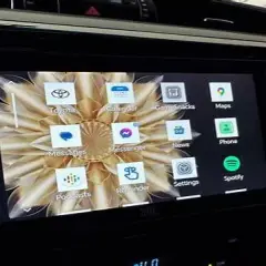 Ekran multimedialny w samochodzie z ikonami aplikacji: Toyota, Calendar, GameSnacks, Maps, Phone, Spotify. Zlink działa płynnie.