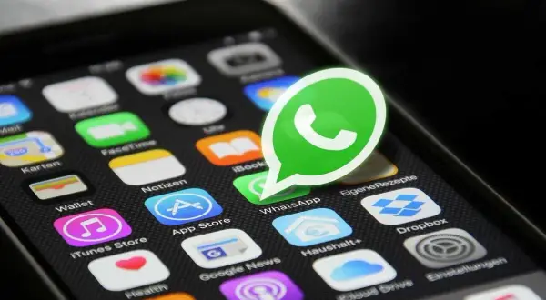 Widok ekranu telefonu z ikonami aplikacji, w tym dużą, zieloną ikoną WhatsApp. Osoba zablokowana na WhatsApp widzi brak możliwości kontaktu.