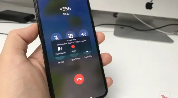 Dłoń trzyma iPhone'a z ekranem rozmowy. Widoczna opcja nagrywanie rozmów z przyciskiem "Start".