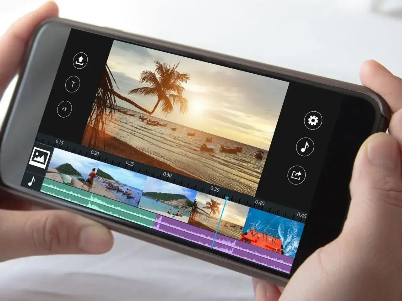 Smartfon z aplikacją do montowania filmów. Na ekranie widać edytor wideo z klipami plażowymi i tropikalną palmą.